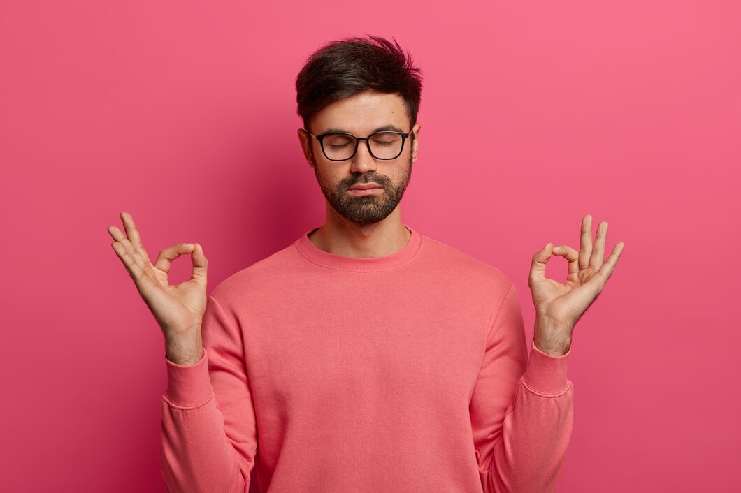 patience-calmness-meditation-concept-peaceful-relieved-bearded-young-man-practices-yoga-exercise-keeps-hands-zen-gesture-closes-eyes-poses-pink-wall-controls-his-emotions_273609-42511.jpg