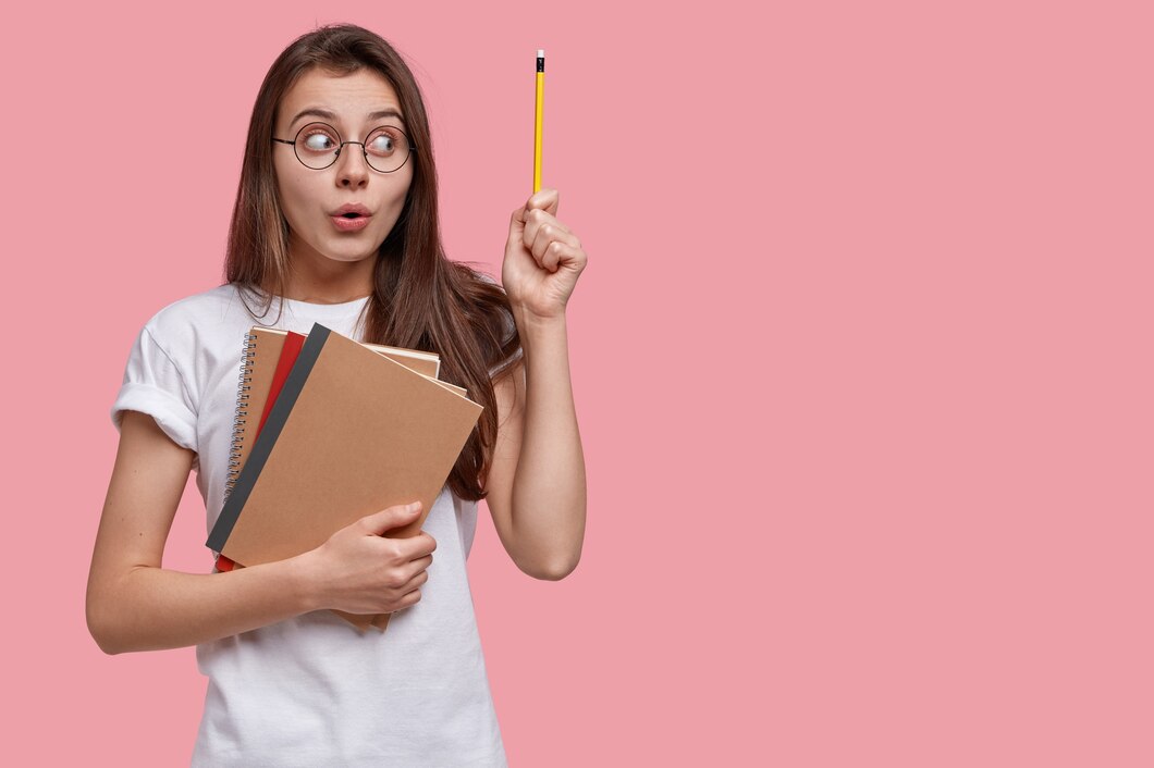 studio-shot-attractive-woman-has-surprised-expression-raises-hand-with-pencil_273609-24147.jpg