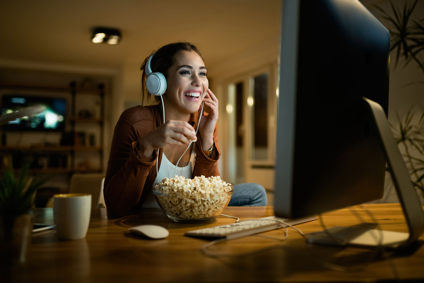 happy_woman_eating_popcorn_watching_movie_desktop_pc_while_enjoying.jpg