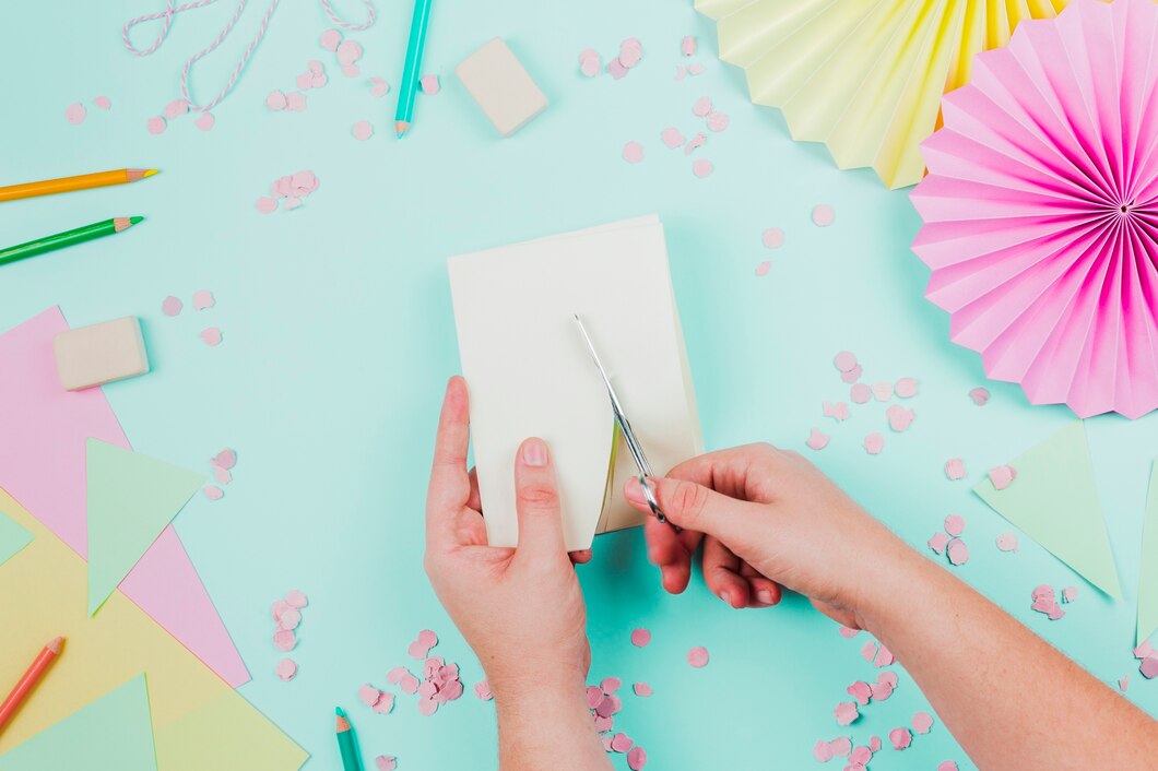 close-up-person-cutting-paper-with-scissor-teal-backdrop_23-2148164467.jpg
