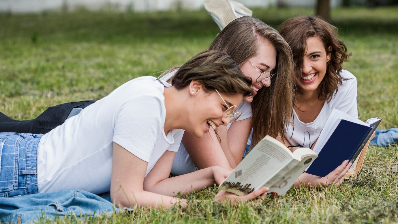 young-friends-reading-lying-park-lawn_23-2147845697.jpg
