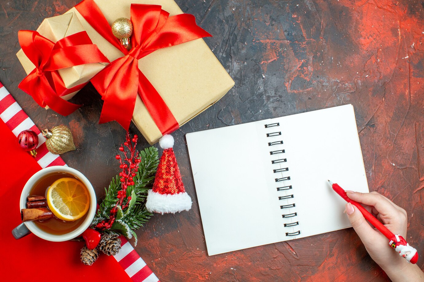 top_view_xmas_gifts_tied_with_red_ribbon_xmas_tree_branch_notepad.jpg