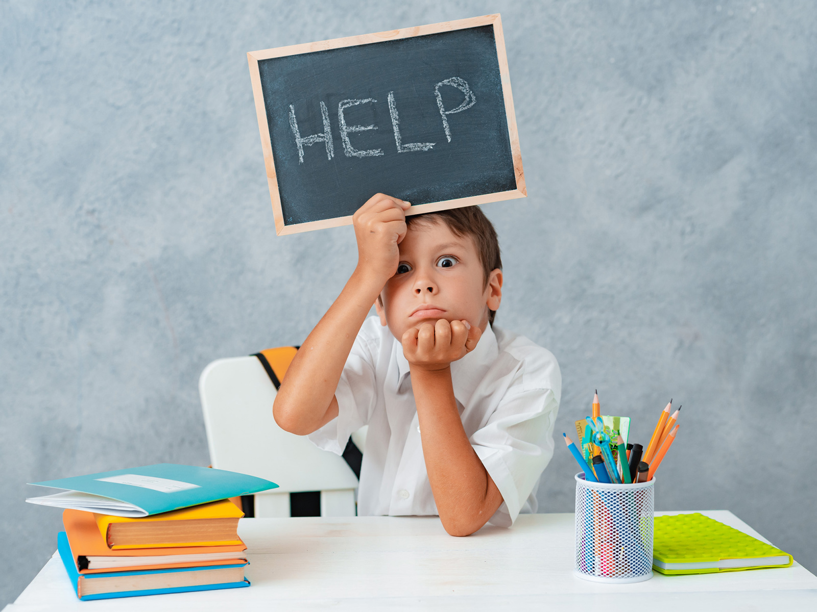 sad_tired_frustrated_schoolboy_boy_at_the_table_and_holding_paper.jpg